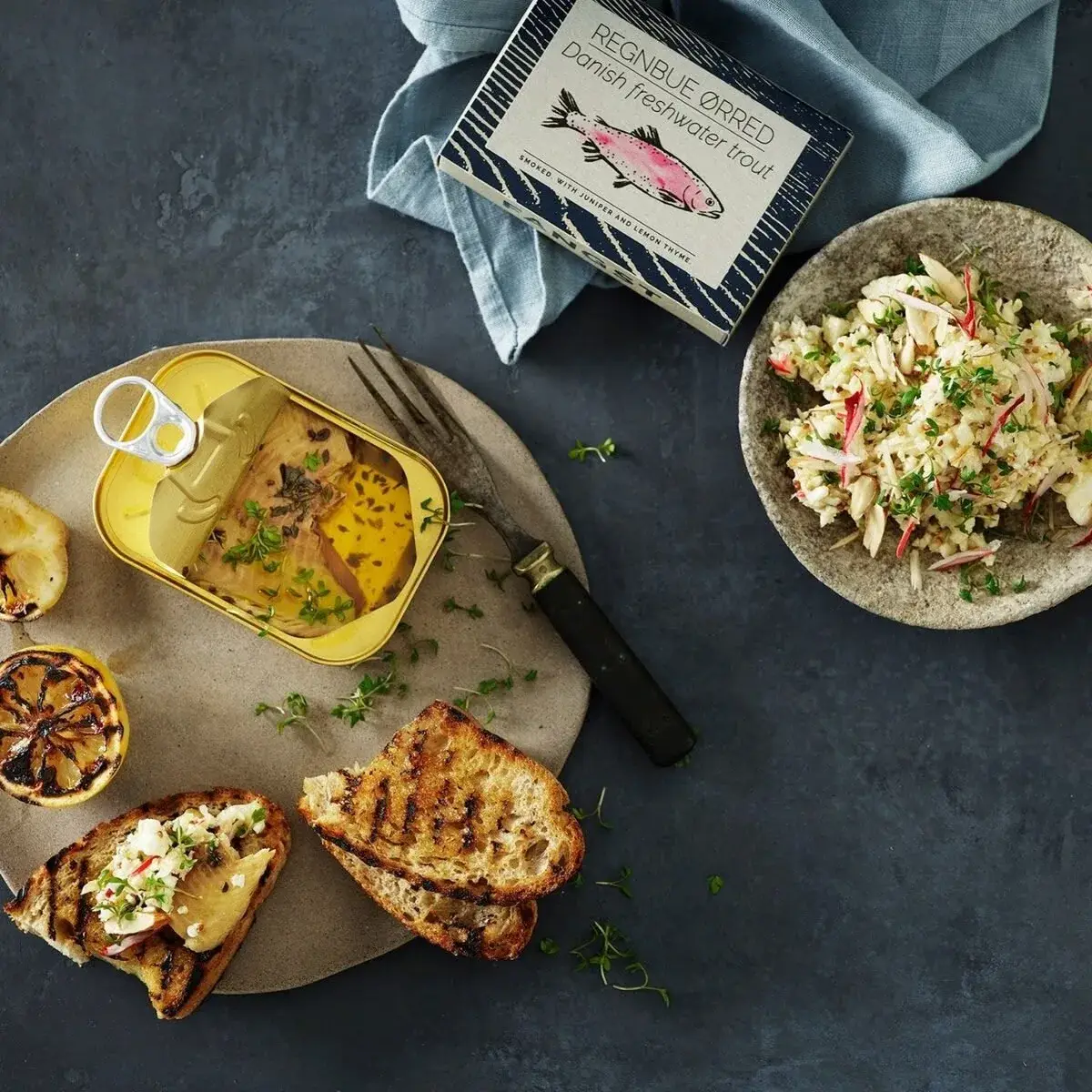 Forelsalade met toast, gegrilde citroen en open blik